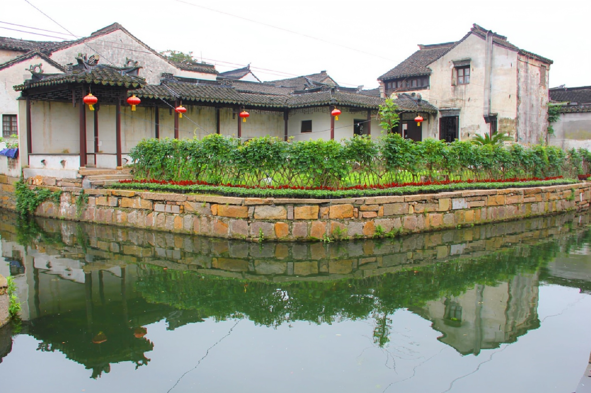 A misty canal lined with whitewashed houses and black-tiled roofs in a Jiangnan water town